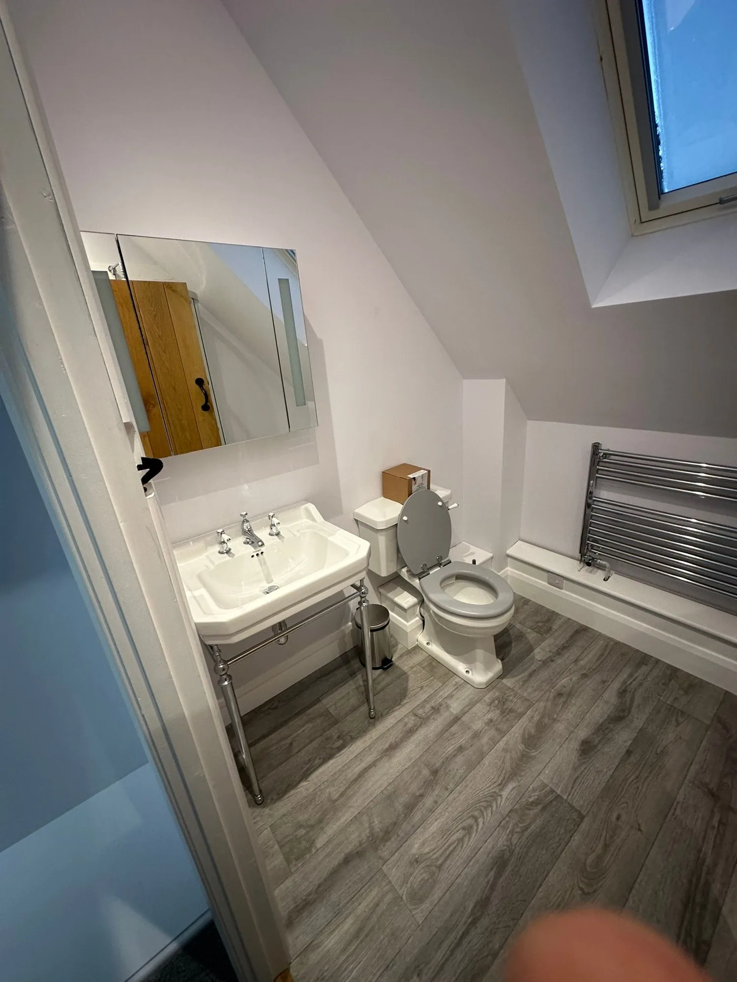Traditional loft ensuite with pedestal basin on chrome legs, close-coupled WC and chrome heated towel rail